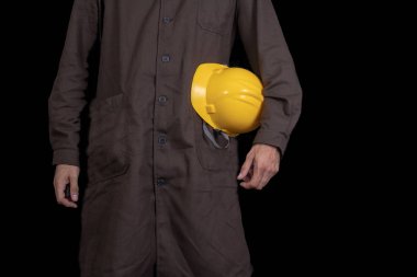Elinde bir koruyucu önlük giyen bir kask ile çalışan. Sağlık koruma çalışanlar. Koyu arka plan.