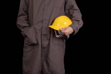 Elinde bir koruyucu önlük giyen bir kask ile çalışan. Sağlık koruma çalışanlar. Koyu arka plan.