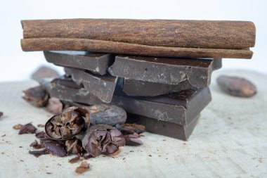 Lezzetli koyu çikolata ve kakao çekirdekleri beyaz bir tablo. Mutfakta tatlılar hazırlamak için kullanılan tatlılar. Beyaz arka plan.