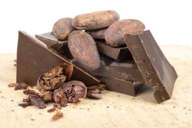 Lezzetli koyu çikolata ve kakao çekirdekleri beyaz bir tablo. Mutfakta tatlılar hazırlamak için kullanılan tatlılar. Beyaz arka plan.