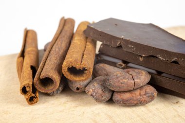 Lezzetli koyu çikolata ve kakao çekirdekleri beyaz bir tablo. Mutfakta tatlılar hazırlamak için kullanılan tatlılar. Beyaz arka plan.