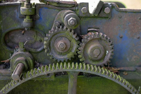 Old rusty gears. Gear wheels in agricultural equipment. Season of the autumn.