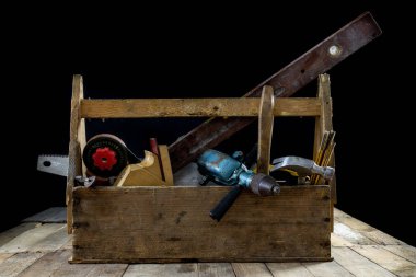 Aksesuarları ile marangoz olarak kutu. Marangozluk aletleri içinde Ahşap Atölyesi tablo üzerinde bir krater. Koyu arka plan.