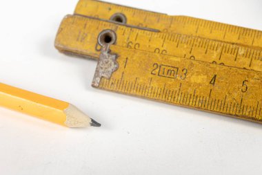 Ölçü ve kalem beyaz atölye masada. Araçlar bir doğrama atölyesinde. Beyaz arka plan.