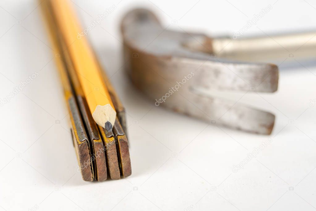 Measure and pencil on a white workshop table. Tools in a carpentry workshop. White background.