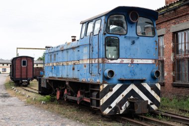 Dar-küçük bir kasabada tren istasyonu hat. Vagon ve lokomotif bir yan hatta bir demiryolu atölye üzerinde. Sezon sonbahar.