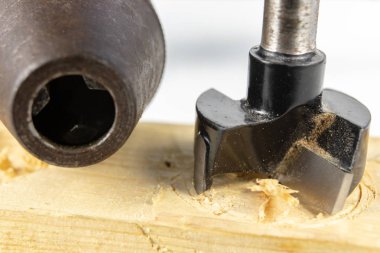 Bir atölyede ahşap matkap ile delik. Doğrama işleri kesme aletleri kullanımı ile yapılır. Beyaz arka plan.