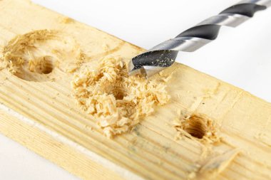 Bir atölyede ahşap matkap ile delik. Doğrama işleri kesme aletleri kullanımı ile yapılır. Beyaz arka plan.