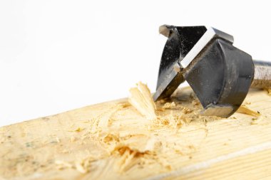 Bir atölyede ahşap matkap ile delik. Doğrama işleri kesme aletleri kullanımı ile yapılır. Beyaz arka plan.