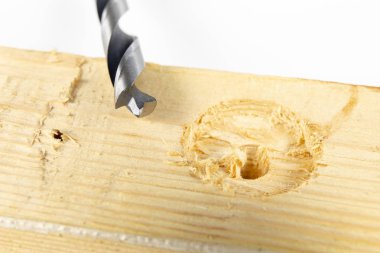 Bir atölyede ahşap matkap ile delik. Doğrama işleri kesme aletleri kullanımı ile yapılır. Beyaz arka plan.