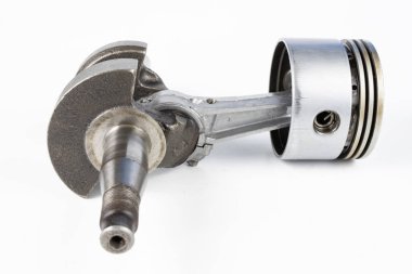 Krank mili ve beyaz bir tablo üzerinde bir küçük yanmalı motor piston. Mekaniği için yedek parçalar. Beyaz arka plan.