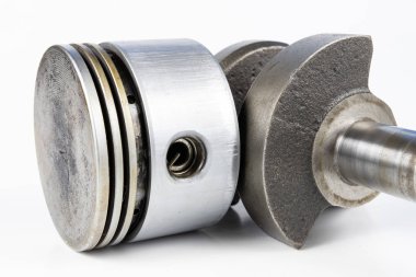 Krank mili ve beyaz bir tablo üzerinde bir küçük yanmalı motor piston. Mekaniği için yedek parçalar. Beyaz arka plan.