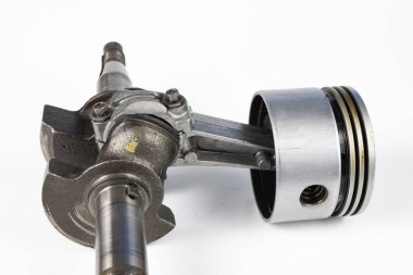 Krank mili ve beyaz bir tablo üzerinde bir küçük yanmalı motor piston. Mekaniği için yedek parçalar. Beyaz arka plan.