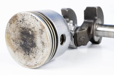 Krank mili ve beyaz bir tablo üzerinde bir küçük yanmalı motor piston. Mekaniği için yedek parçalar. Beyaz arka plan.