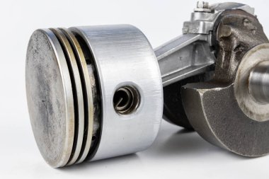 Krank mili ve beyaz bir tablo üzerinde bir küçük yanmalı motor piston. Mekaniği için yedek parçalar. Beyaz arka plan.