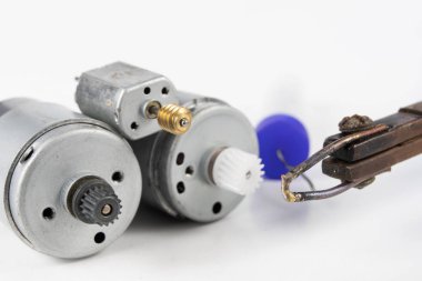 Küçük bir elektrik motoru tamiri. Elektronik Atölyesi, basit lehimleme adet eser bulunmaktadır. Beyaz arka plan.