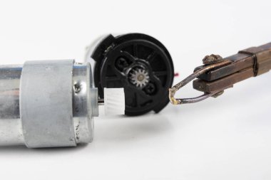Küçük bir elektrik motoru tamiri. Elektronik Atölyesi, basit lehimleme adet eser bulunmaktadır. Beyaz arka plan.