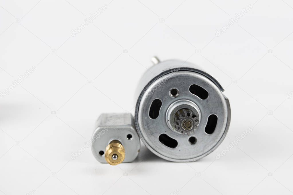Small electric motor for household appliances. Electric drive powered by low voltage. White background.