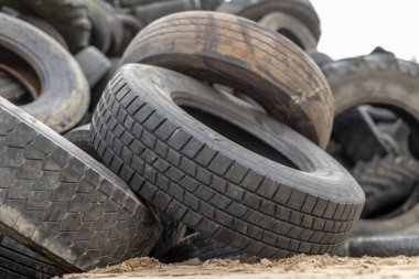 A stack of tires on an old garbage dump. Old worn out tires piled up. Season of the autumn. clipart