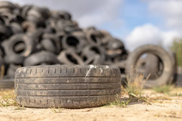 A stack of tires on an old garbage dump. Old worn out tires piled up. Season of the autumn.