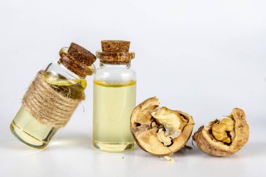 Yağ bir şişe ve ceviz beyaz mutfak masası üzerinde. Baharat ve malzemeleri kuchi içinde yararlı. Beyaz arka plan.