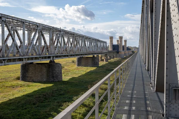 Old railway bridge with pedestrian barriers. Railway bridge over the river. Season of the autumn.