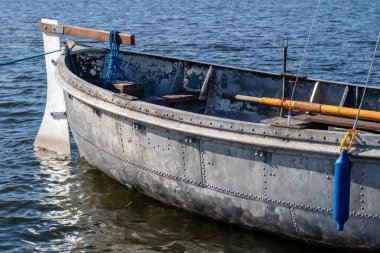 Metal ve perçin yapılmış eski bir tekne. Gemi köprüye gölün palamarla. Sezon sonbahar.