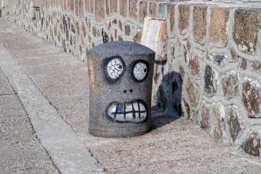 Baba bir halatı ile etrafına sarılmış. Yat limanında demirli tekneler. Yaz sezonu.