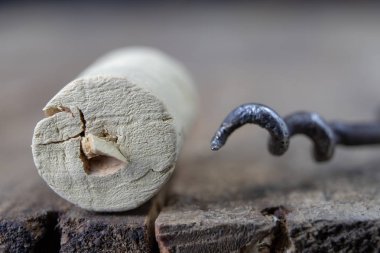 Eski bir tirbuşon şarap mantarlar için. Ahşap mutfak masasında açık eski şarap. Koyu arka plan.