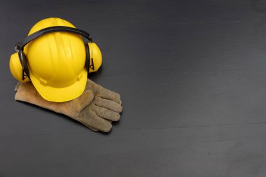 Kask ve bir siyah tezgah eldiven. Giyim inşaat işçileri için çalışıyorum. Koyu arka plan.