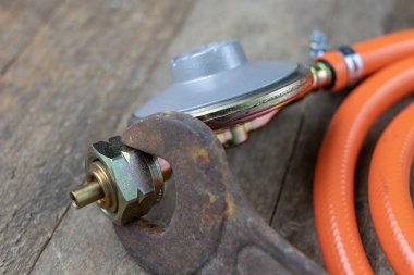 Regülatör propan bütan gaz silindir ve aksesuar Ahşap Atölyesi masada. Gaz aksesuar atölyesinde. Koyu arka plan.