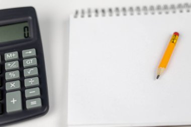 Notlar ve kalem ofis masaya ayırdığınız için Not defteri. Tırnak ve ezber muhasebe alanında gerekli aksesuarları. Beyaz arka plan.