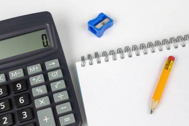 Notlar ve kalem ofis masaya ayırdığınız için Not defteri. Tırnak ve ezber muhasebe alanında gerekli aksesuarları. Beyaz arka plan.