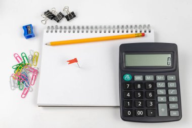 Notlar ve kalem ofis masaya ayırdığınız için Not defteri. Tırnak ve ezber muhasebe alanında gerekli aksesuarları. Beyaz arka plan.
