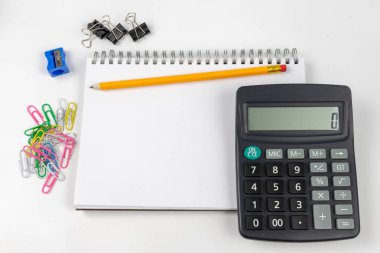 Notlar ve kalem ofis masaya ayırdığınız için Not defteri. Tırnak ve ezber muhasebe alanında gerekli aksesuarları. Beyaz arka plan.