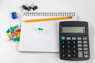 Notlar ve kalem ofis masaya ayırdığınız için Not defteri. Tırnak ve ezber muhasebe alanında gerekli aksesuarları. Beyaz arka plan.