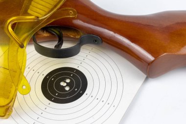 Kalkan ve pnömatik silah beyaz bir tablo. Çekim mesafeden çekim spor için aksesuarlar. Açık renkli.