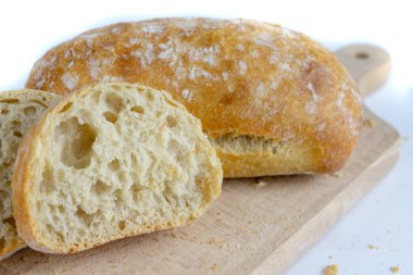 Taze ekmek ahşap mutfak tahtası. Bir dilim ekmek ve tereyağı ile bulaşmış. açık renkli.