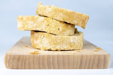 Taze ekmek ahşap mutfak tahtası. Bir dilim ekmek ve tereyağı ile bulaşmış. açık renkli.