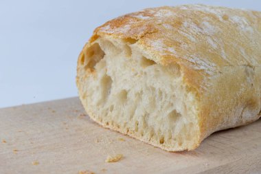 Taze ekmek ahşap mutfak tahtası. Bir dilim ekmek ve tereyağı ile bulaşmış. açık renkli.