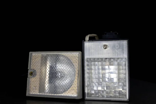 Old flash lamps on a metal table. Photo accessories from central europe. Dark background.