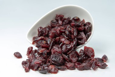 Beyaz bir kase lezzetli kurutulmuş kızılcık. Mutfak masasında kek için davranır. Beyaz arka plan.