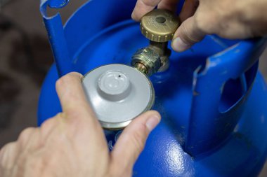 Regülatör propan bütan gaz silindir ve aksesuar Ahşap Atölyesi masada. Gaz aksesuar atölyesinde. Koyu arka plan.