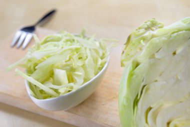 Taze beyaz lahana mutfak masasında şeritler halinde kesin. Sebze salatası için hazırlanmış. Açık renkli.