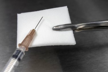 Steril bez, pense ve tıbbi şırınga bir hastane tablo. Doktorun ofisinden aksesuarları. Açık renkli.