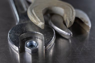 İngiliz anahtarı ve fındık bir atölyede metal bir tablo. Mechaics küçük mekanik tamir için aksesuarlar. Açık renkli.