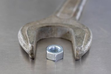 İngiliz anahtarı ve fındık bir atölyede metal bir tablo. Mechaics küçük mekanik tamir için aksesuarlar. Açık renkli.