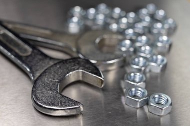 İngiliz anahtarı ve fındık bir atölyede metal bir tablo. Mechaics küçük mekanik tamir için aksesuarlar. Açık renkli.