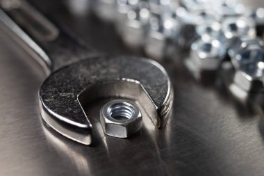 İngiliz anahtarı ve fındık bir atölyede metal bir tablo. Mechaics küçük mekanik tamir için aksesuarlar. Açık renkli.