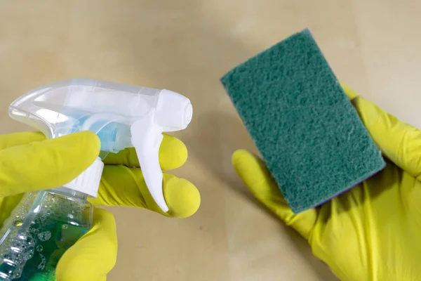 Sponge and liquid for cleaning the surface at home. Accessories for keeping household clean. Light background.